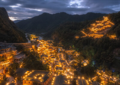 A beautiful night view of a mountain village with lights on